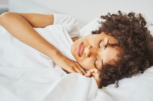 A peaceful woman sleeping in bed, symbolizing the connection between quality rest and healthy weight management.