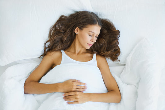 A woman sleeping peacefully while wrapped in a blanket, symbolizing rest and immune support.