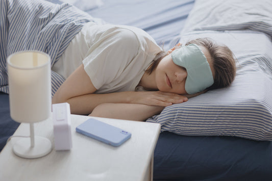 A smart sleep tracker, white noise machine, and LED sleep light on a nightstand