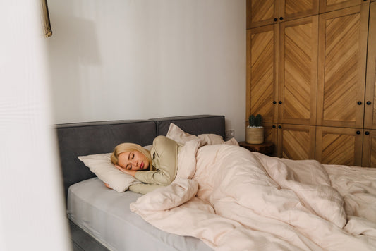 A person peacefully sleeping under a soft weighted blanket