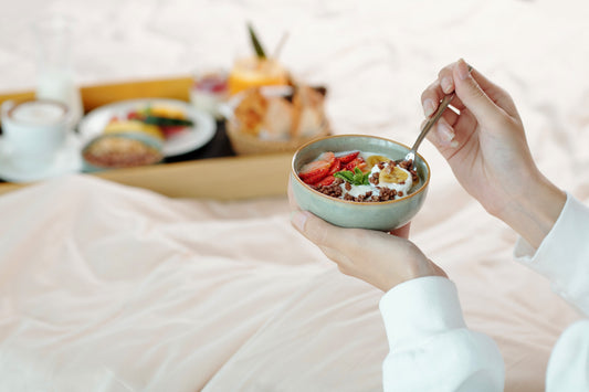 Bowl of oatmeal, tart cherries, and almonds arranged as healthy bedtime snacks for better sleep.