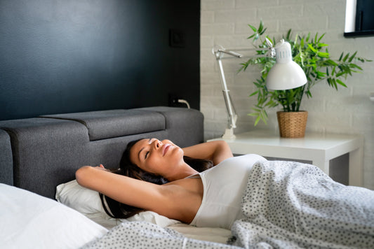 Woman sleeping peacefully in bed surrounded by calm lighting and serene mood.