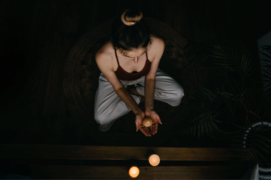 Person meditating in bed at night with dim lighting and peaceful atmosphere