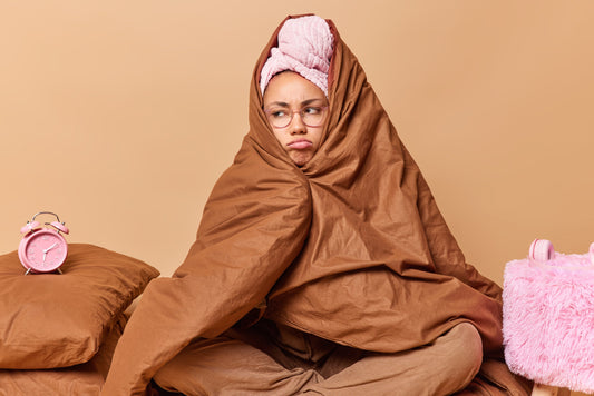 A cozy heated blanket on a bed with soft pillows and warm lighting