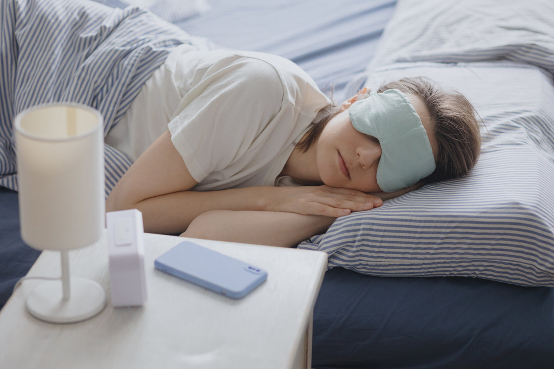 A smart sleep tracker, white noise machine, and LED sleep light on a nightstand